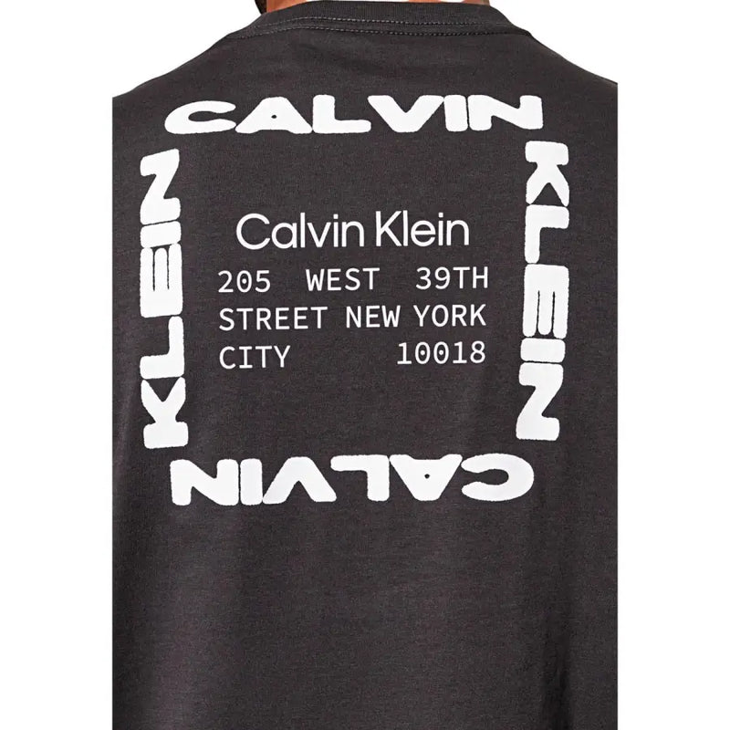 Schwarz Calvin Klein Jeans Männer t-shirt mit einer auffälligen weißen Grafik und moderner Schriftart, die den Markennamen und die New Yorker Adresse anzeigt