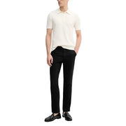 Calvin Klein Jeans Herrenhose kombiniert mit einem cremefarbenen, gerippten Poloshirt mit klassischem Kragen und kurzen Ärmeln