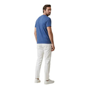 Ein Mann in Weiß Calvin Klein Jeans Herrenhose kombiniert mit einem einfarbig blauen Kurzarmhemd t-shirt