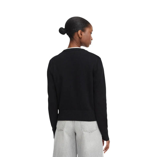 Calvin Klein Jeans Schwarzer Damen-Strickpullover aus Baumwolle mit gerippten Bündchen und Saum, getragen über hellen Jeans.