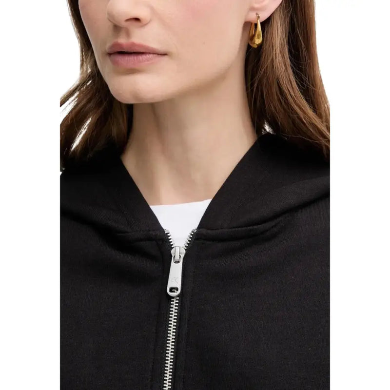 Gold hoop earrings with a sleek modern design paired with a calvin klein jeans women black hooded zip sweatshirt