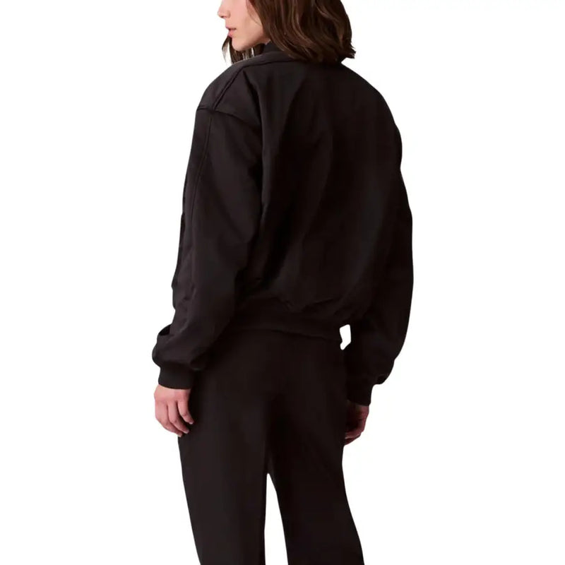 Calvin Klein Jeans women black polyester bomber jacket with ribbed cuffs and waistband shown from the back side
