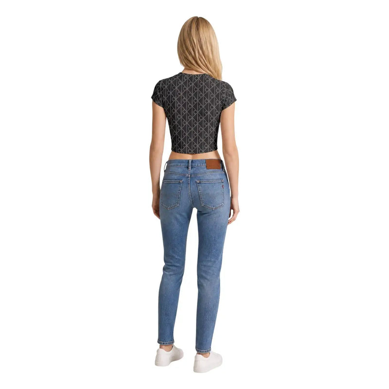 Eine hellblaue Skinny-Jeans mit braunen Ledergürtelschlaufen, kombiniert mit einem grauen Baumwoll-T-Shirt von Calvin Klein Jeans für Damen mit Rundhalsausschnitt.
