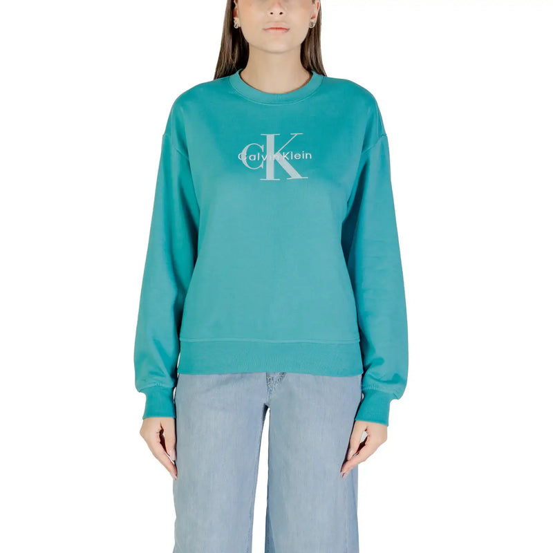 Woman wearing teal Calvin Klein sweatshirt with light blue wide-leg pants for casual style