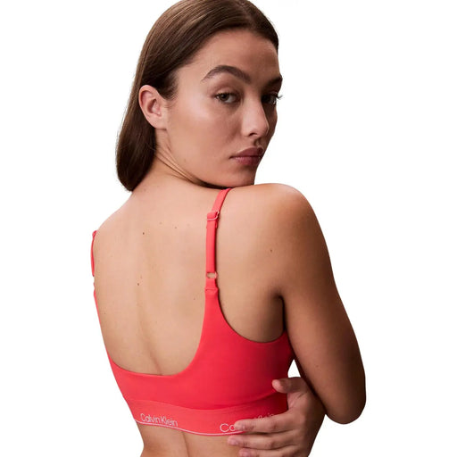 Calvin Klein Jeans Orangefarbenes Bralette-Strandoutfit für Damen mit nahtlosem Sport-BH in leuchtendem Korallenrot und dünnen, verstellbaren Trägern.