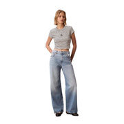 Eine hellblaue, weit geschnittene Jeans im klassischen Five-Pocket-Design, kombiniert mit einem schwarzen, gestreiften Rundhals-Shirt von Calvin Klein für Damen. top
