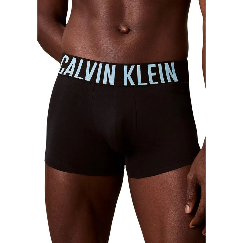Black Calvin Klein men cotton trunks featuring light blue logo waistband in a 3 pack set