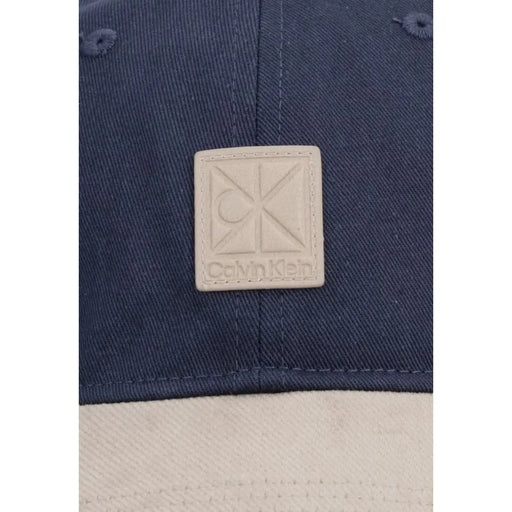 Marineblaue Denim-Baumwollkappe mit beigefarbenem Calvin Klein Logo-Patch aus Leder aus der Calvin Klein Herren Mixed Media Colorblock Kollektion