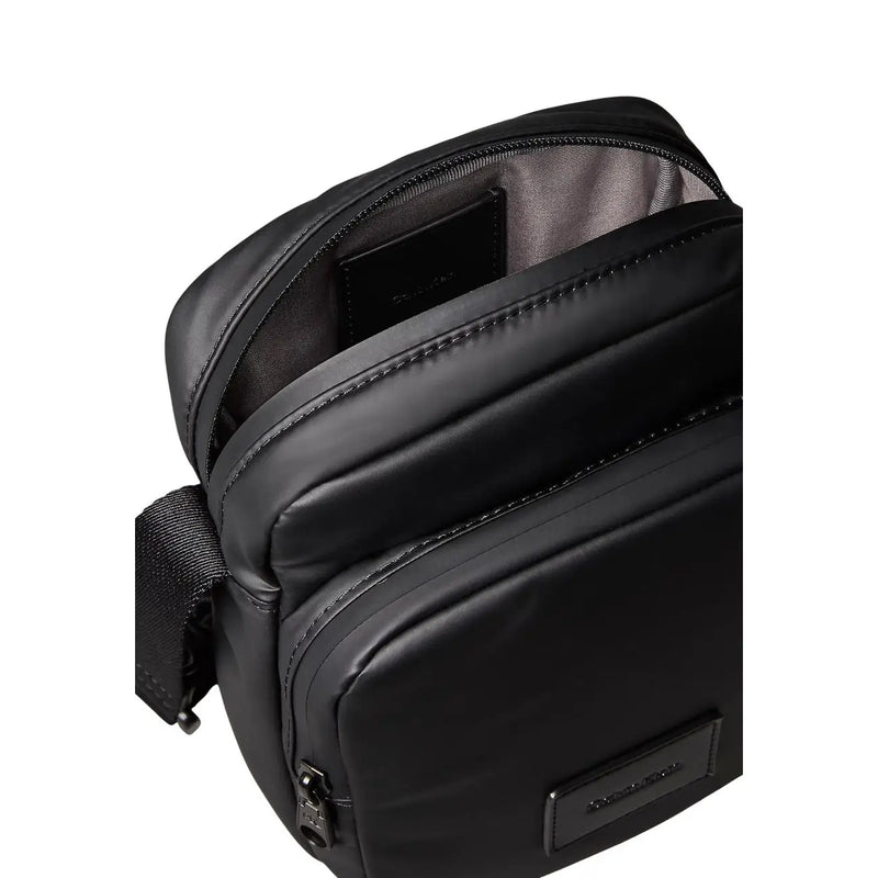 Calvin Klein Schwarze Herren-Puffertasche aus Nylon mit elegantem, minimalistischem Design und dezenten Ziernähten.