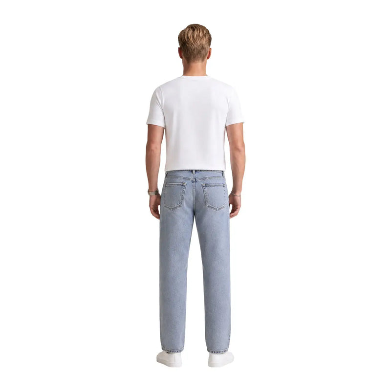 Hellblaue Jeans mit geradem Bein und klassischen Gesäßtaschen, kombiniert mit einem weißen Baumwoll-T-Shirt von Calvin Klein für Herren mit Grafikprint.