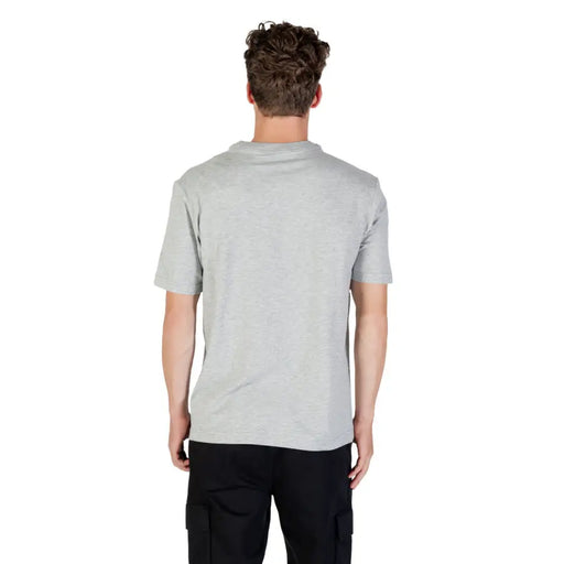 Man wearing Calvin Klein Sport grey round neck T shirt and black cargo pants