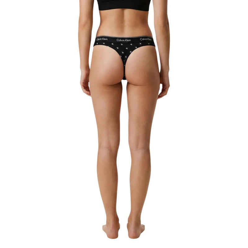 Schwarzer Calvin Klein Damen-Tanga im brasilianischen Stil aus Baumwoll-Modal mit weißem Logo und Sternenmuster, von hinten gesehen