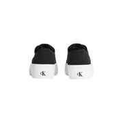 Black canvas slip-on sneakers with thick white rubber sole and ck logo on heel shown from the back side