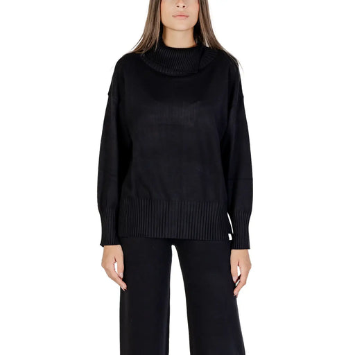 Schwarzer Strickpullover von Choral für Damen mit Rollkragen, Rippstrickdetails an Halsausschnitt, Bündchen und Saum.