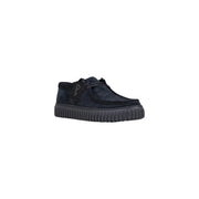 Schwarze Schnürstiefel aus Wildleder von Clarks für Herren, dazu ein dunkelblauer Wildleder-Slipper und eine gerippte Gummisohle.