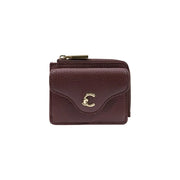 A compact burgundy textured leather wallet with gold tone c logo clasp and zipper pull for women by coccinelle