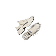 Cream-colored converse women slip on fabric sneakers with black rubber soles and contrasting black stitching