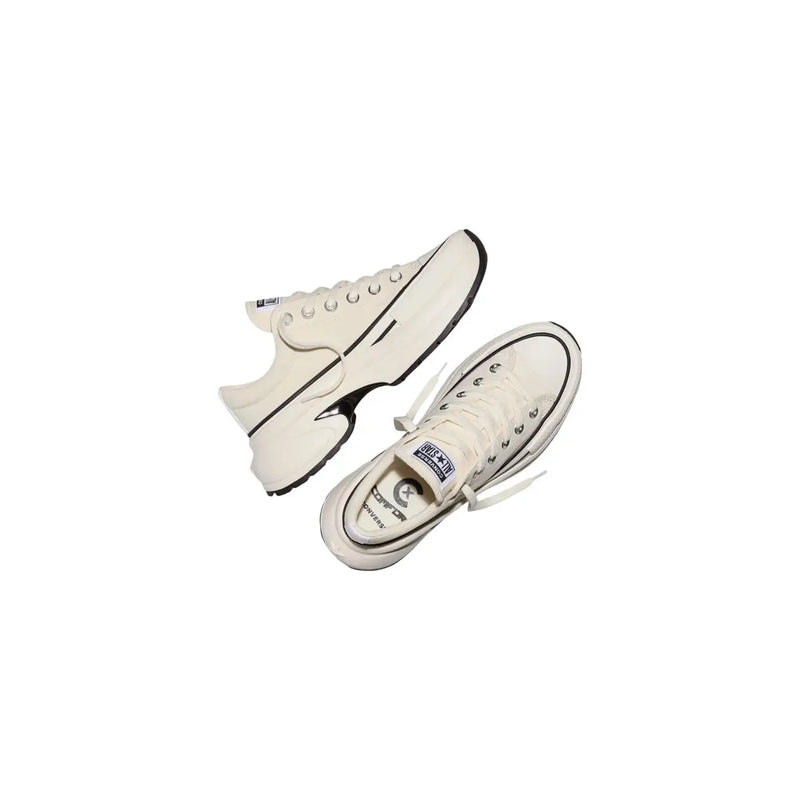 Cream-colored converse women slip on fabric sneakers with black rubber soles and contrasting black stitching