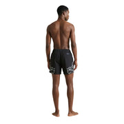 Schwarze Herren-Badeshorts aus bedrucktem Polyester von County of Milan mit auffälligem weißen Blumenmuster an den Unterschenkeln