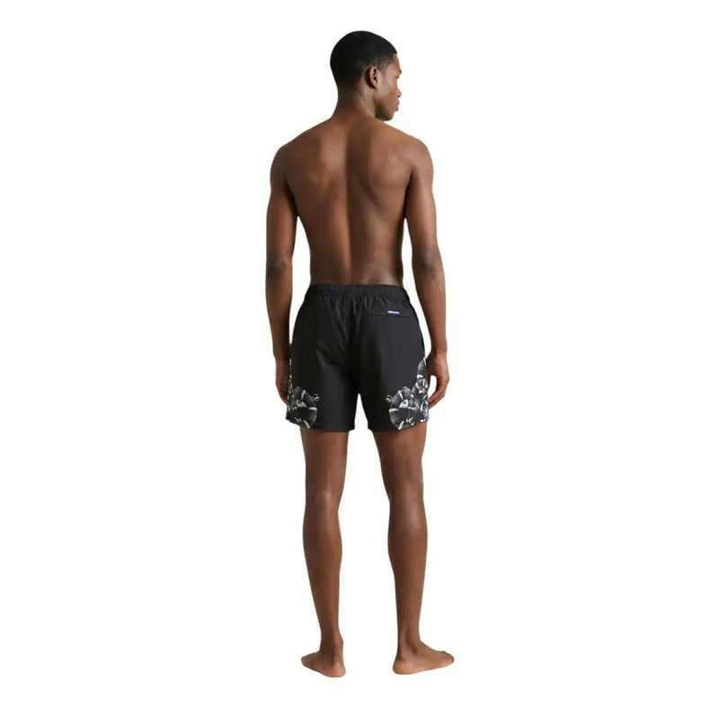 Schwarze Herren-Badeshorts aus bedrucktem Polyester von County of Milan mit auffälligem weißen Blumenmuster an den Unterschenkeln