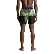 Black swim trunks by County of Milan featuring symmetrical green and yellow outstretched wings graphic on the back