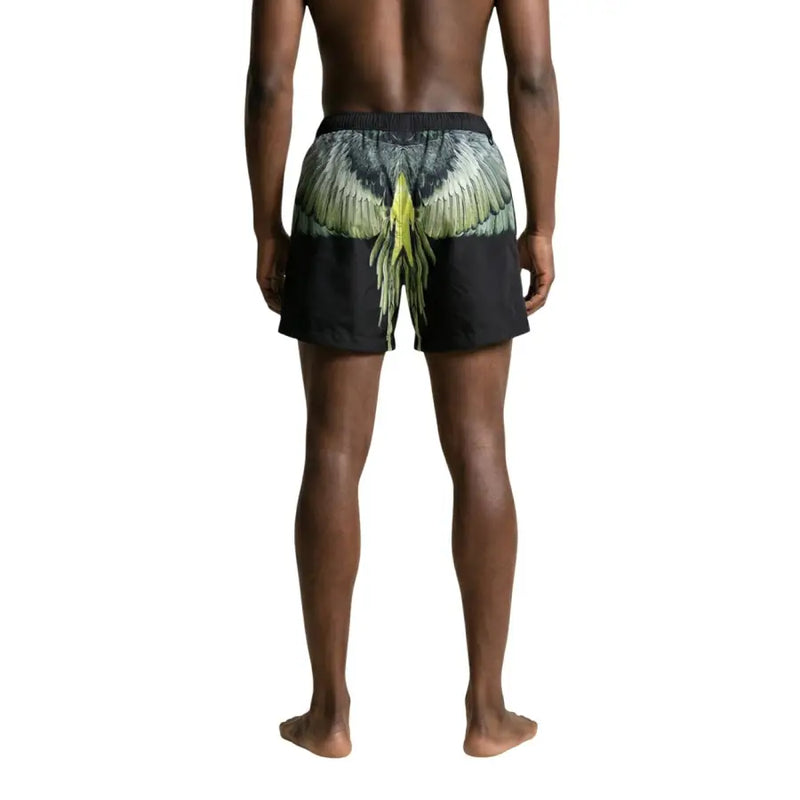 Black swim trunks by County of Milan featuring symmetrical green and yellow outstretched wings graphic on the back