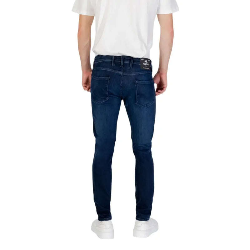 Dark blue slim-fit jeans paired with white sneakers in a men’s fashion display