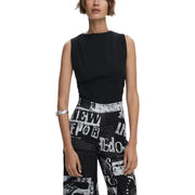 Black sleeveless boat neck top paired with black and white newspaper print wide-leg pants