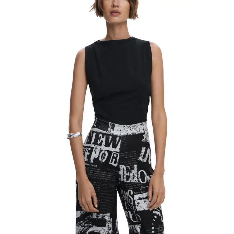 Black sleeveless boat neck top paired with black and white newspaper print wide-leg pants