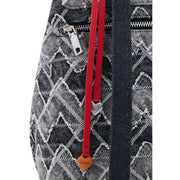 Red leather strap with heart-shaped charms attached to black and white geometric patterned Desigual grey cotton rucksack