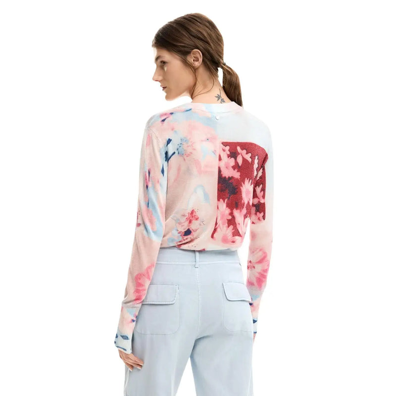 A woman wears desigual pink floral long sleeve round neck viscose knitwear with a soft flowing fabric