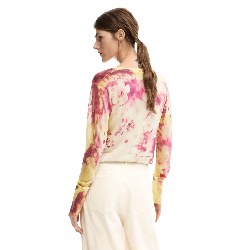 A woman wears desigual pink floral long v-neck knitwear featuring a vibrant pink and yellow floral pattern