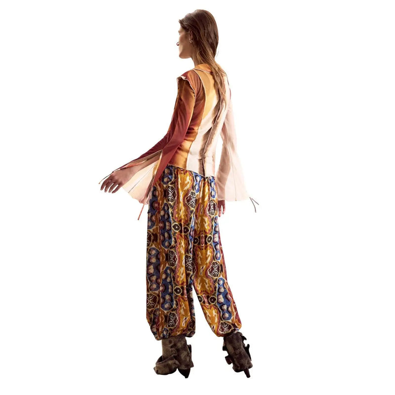 A woman wears a desigual women beige long sleeve round neck classic shirt with sheer layered sleeves and patterned wide-legged pants