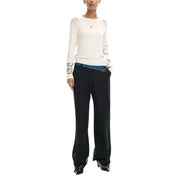 Desigual women beige long sleeve knitwear with black embroidered script on shoulders and cuffs worn over blue denim waistband