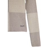 Beige-grau gestreifter Rippstrickschal mit dezent gesticktem Logo, kombiniert mit einem beigefarbenen Rollkragenpullover von Desigual für Damen.