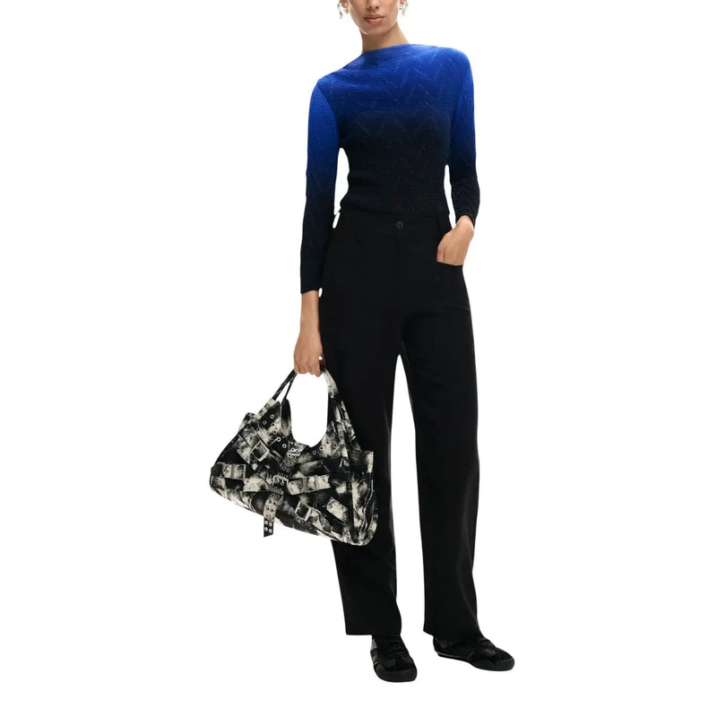 Schwarze Viskosehose für Damen von Desigual mit Taschen, kombiniert mit einer schwarz-weiß gemusterten Schultertasche mit überlappenden Gürtelschnallen.