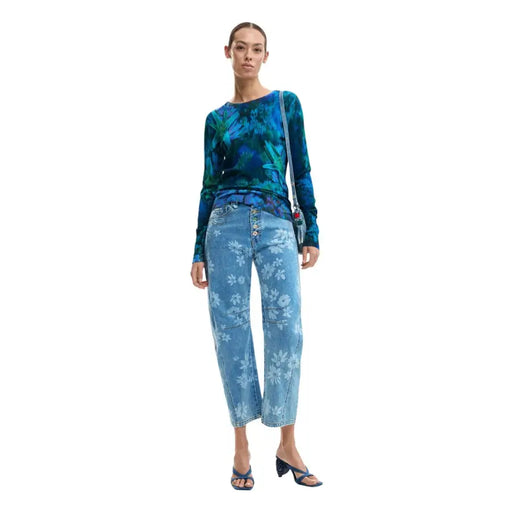 Desigual Damen-Strickpullover mit blauem Blumenmuster, langen Ärmeln und Rundhalsausschnitt, kombiniert mit einer blauen Jeans mit Blumenmuster und weißen Blüten