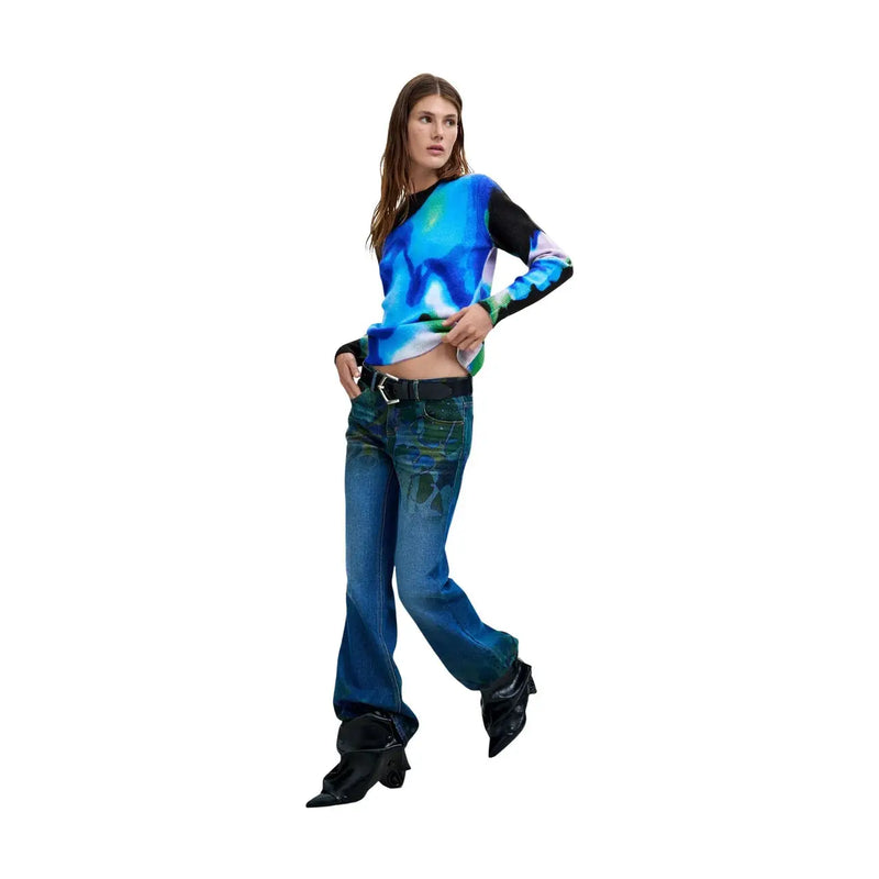Eine Frau trägt ein blaues, schmal geschnittenes Langarmshirt aus Acrylmischgewebe von Desigual für Damen. top mit leuchtendem Batikmuster und schwarzen Ärmeln