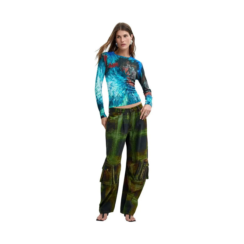 Eine Frau trägt einen blauen Viskose-Strickpullover von Desigual mit einem blau-schwarzen Federmuster auf der Vorderseite.