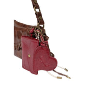 Desigual Damenhandtasche aus braunem Kunstleder, 17 cm, abgebildet als glänzend rote, herzförmige Geldbörse mit strukturierter Oberfläche und goldfarbenen Beschlägen.