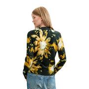 Ein schwarzer Strickpullover aus Acrylmischgewebe von Desigual mit einem auffälligen gelb-weißen Gänseblümchenmuster im Batik-Stil.