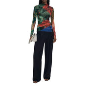 Women wearing Desigual green viscose long-sleeve floral top with black trousers and white clutch