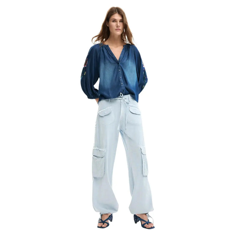 Blaue Jeansbluse mit bestickten Ärmeln und Knopfleiste, kombiniert mit einer hellblauen Baumwollhose mit Schnürung von Desigual für Damen.
