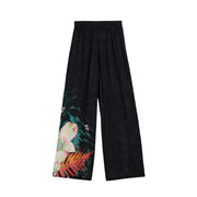 Schwarze, weit geschnittene Viskosehose von Desigual mit lebhaftem tropischem Blumenmuster mit rosa Blüten und orangefarbenen Blättern