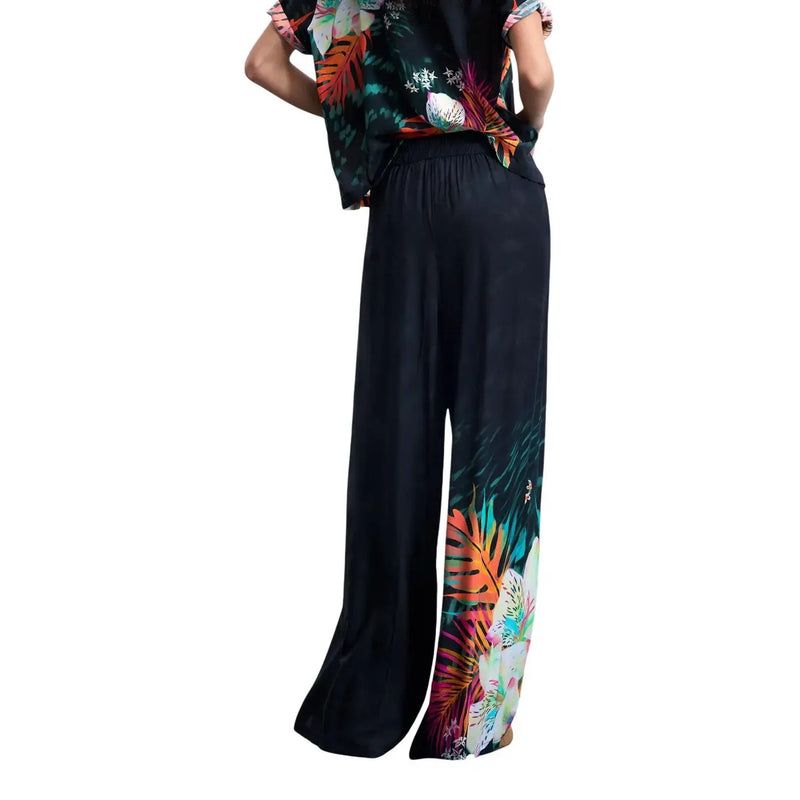 Schwarze, weite Viskosehose von Desigual für Damen mit einem lebhaften tropischen Blätterprint in Orange, Grün und Pink an den Unterschenkeln