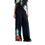 Schwarze, weit geschnittene Viskosehose von Desigual mit einem lebhaften tropischen Blumenmuster an der Seite