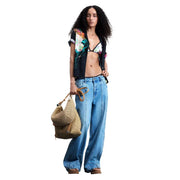Woven straw tote bag with natural fiber handles and drawstring closure paired with black Desigual floral viscose shirt