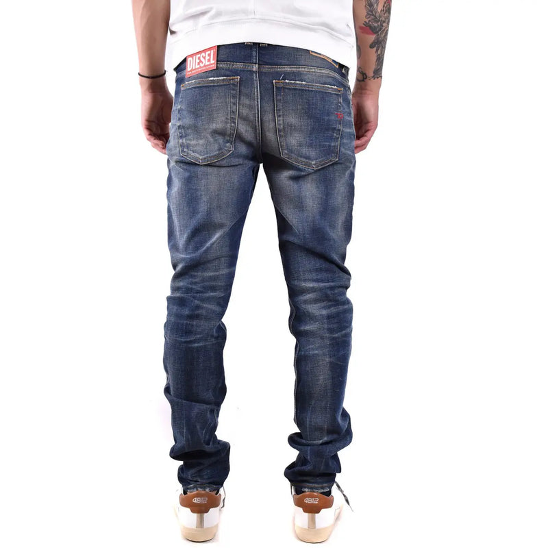 Dark blue denim jeans with faded wash and distressed details showing diesel label on the back waistband