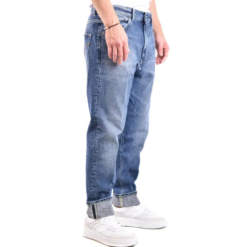 Blaue Jeans mit Used-Look und weiße Sneaker.