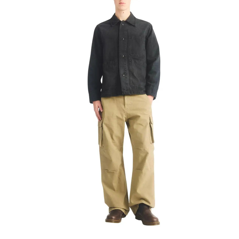 Schwarze Jeansjacke mit Knopfverschluss und mehreren Taschen, kombiniert mit braunen Dr. Martens Herren-Lederstiefeln, Modell Classic 2976